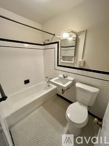 A white toilet sits next to a sink in a small bathroom.
