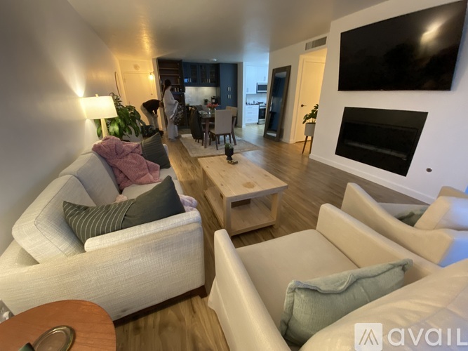 A living room with a couch, a chair, a coffee table, and a television.