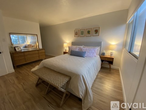 A bedroom with a large bed and a wooden dresser.