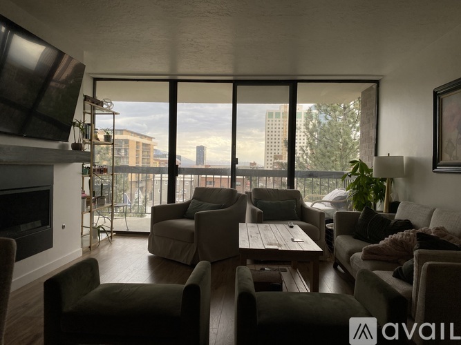 A living room with a fireplace and a view of the city.