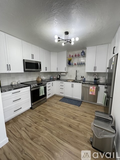 A kitchen with white cabinets and a black stove top.