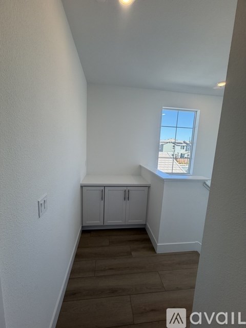 A room with white walls and a window overlooking a building.