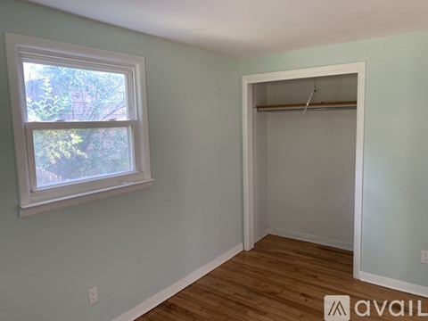 A room with a window and a closet.