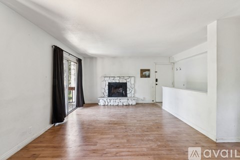 A living room with a fireplace and a sliding glass door.