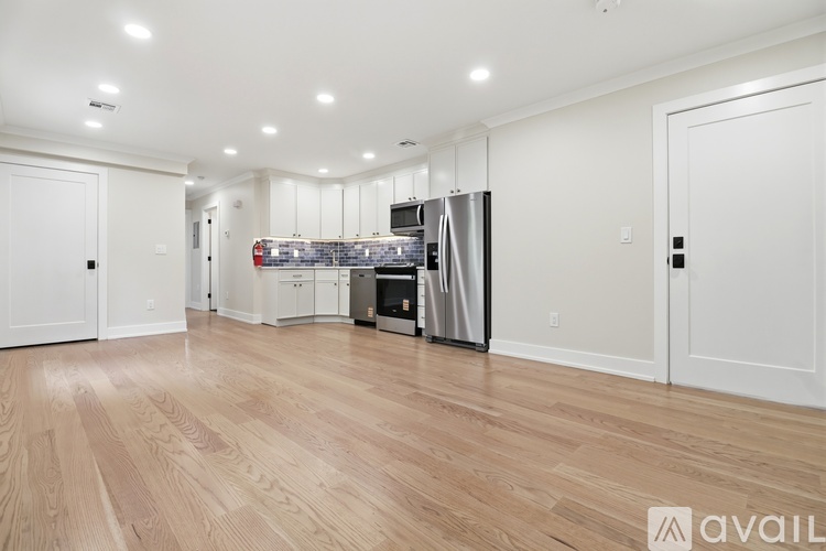A kitchen with wooden floors and white walls.