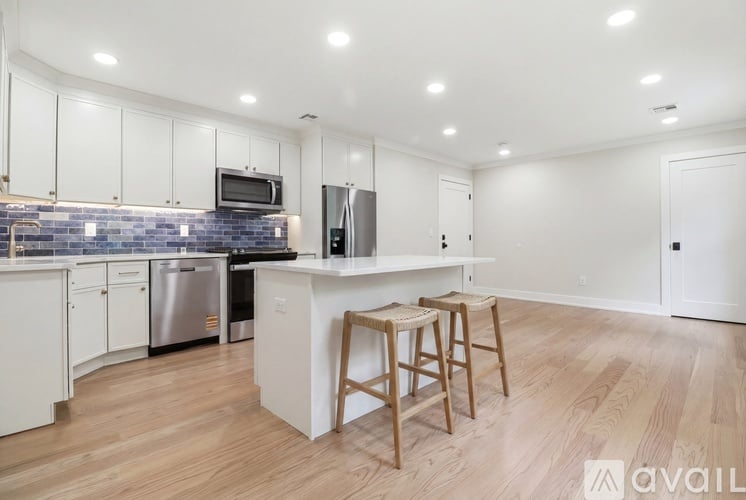 A kitchen with white cabinets and a wooden island.