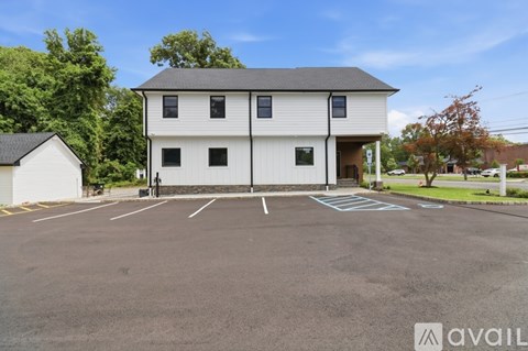 A large white building with a parking lot in front.