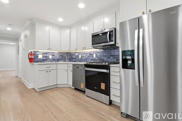 A kitchen with a stainless steel refrigerator, oven, and microwave.