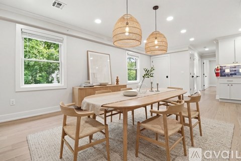 A dining room with a wooden table and chairs.