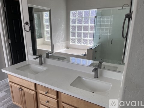 A bathroom with two sinks and a large mirror.