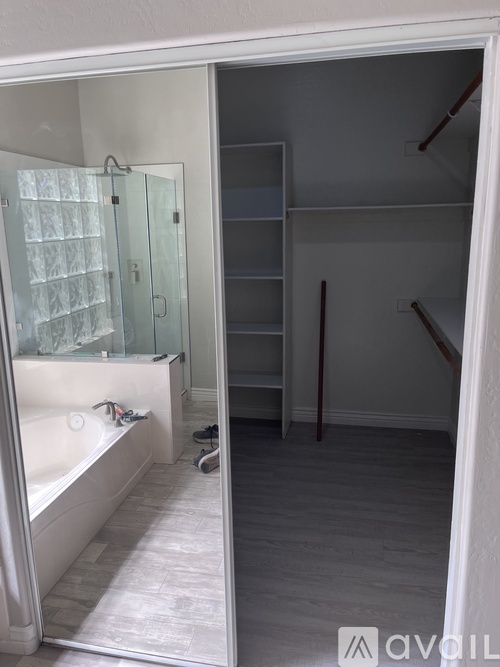 A bathroom with a glass shower door and a bathtub with a glass door.