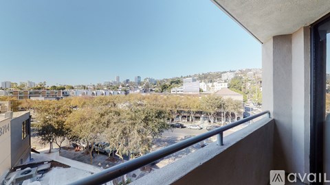 A balcony overlooks a parking lot and buildings.