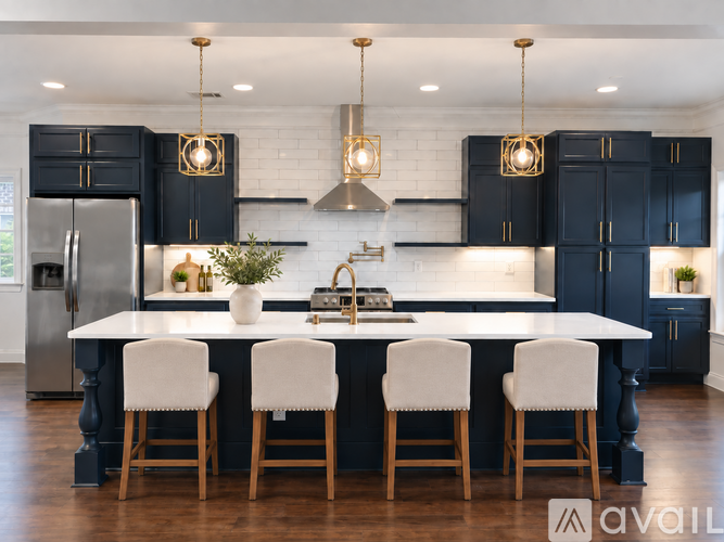 A modern kitchen with a large island and white chairs.