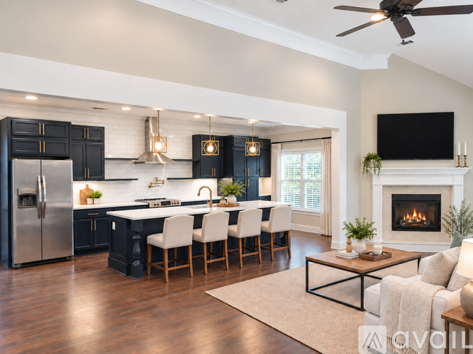 A modern kitchen with a black fridge and a fireplace in the living room.