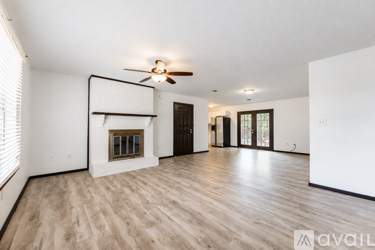 A spacious living room with a fireplace and hardwood floors.