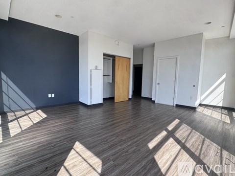 A room with wooden flooring and white walls is available for rent.