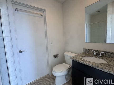 A bathroom with a toilet, sink, and mirror.
