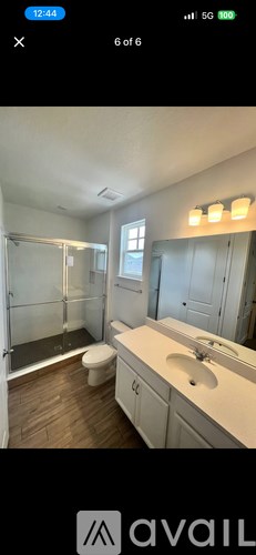 A bathroom with a toilet, sink, and mirror.