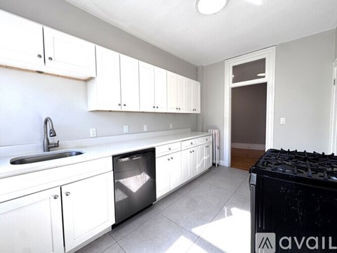 A kitchen with white cabinets and a black stove top.