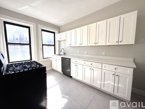A kitchen with white cabinets and a black stove top.