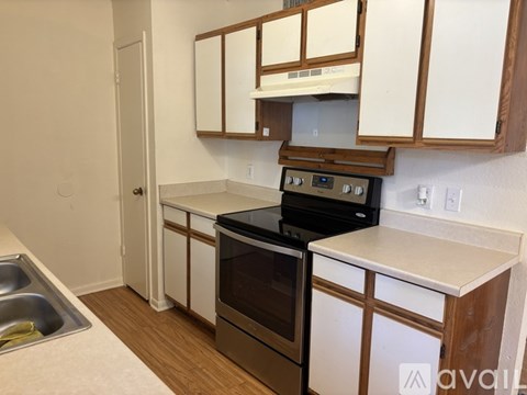 A kitchen with white cabinets and a black stove top oven.