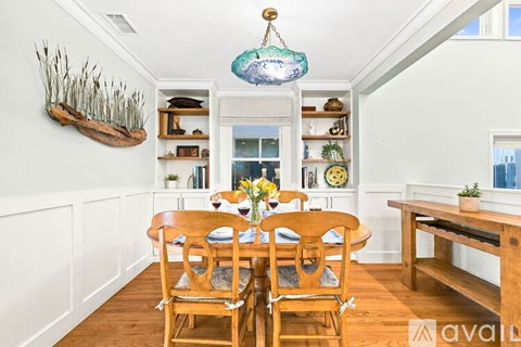 A dining room with a wooden table and chairs.