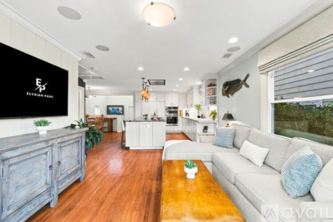 A living room with a white couch and a wooden floor.