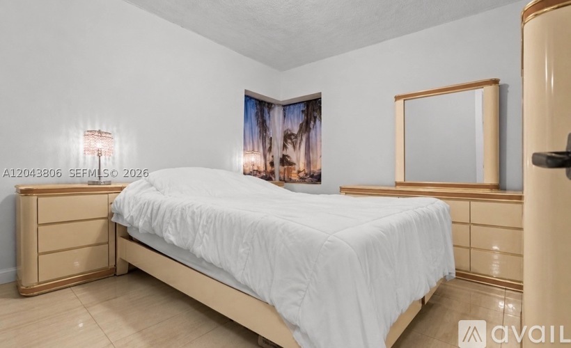 A bedroom with a bed, dresser, and a painting on the wall.