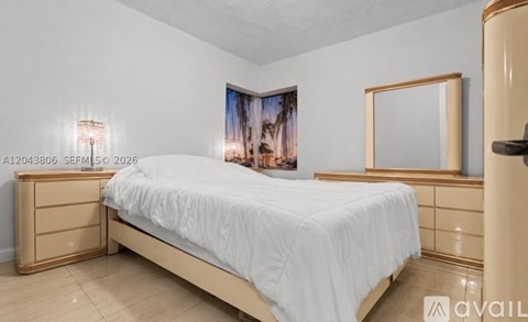 A bedroom with a bed, dresser, and a painting on the wall.