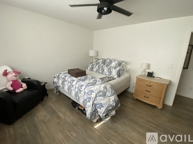 A bedroom with a bed, nightstand, and a ceiling fan.