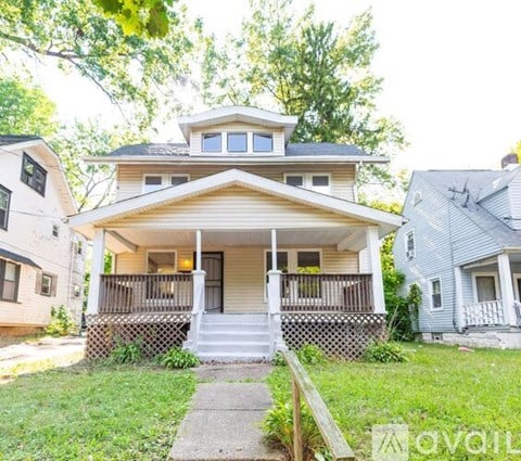 A two-story house with a front porch and a small front yard.
