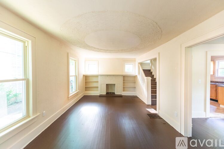A spacious living room with hardwood floors and a fireplace.