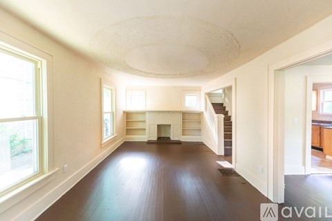 A spacious living room with hardwood floors and a fireplace.
