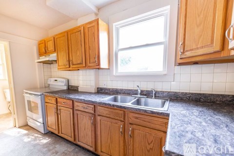 A kitchen with wooden cabinets and a marble countertop.
