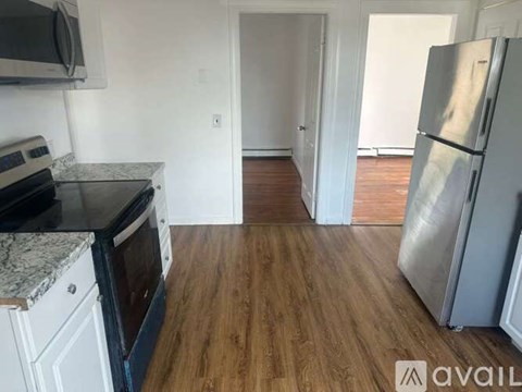 A kitchen with a black stove top oven and a black microwave above a granite countertop.