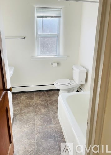 A bathroom with a toilet, sink, and tub.
