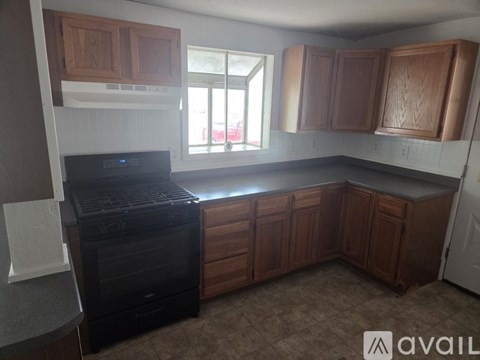 A kitchen with brown cabinets and a black stove top oven.