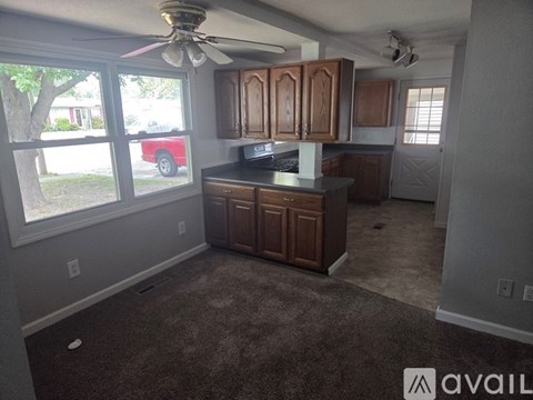 A kitchen with brown cabinets and a ceiling fan.