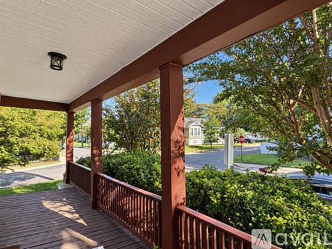 A porch with a white ceiling and red pillars.