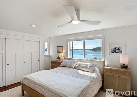 A bedroom with a large bed and a view of the water.
