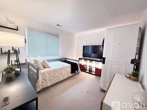 A bedroom with a bed, a television, and a desk.