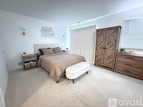 A bedroom with a bed, nightstand, and wardrobe.