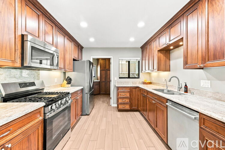 A kitchen with wooden cabinets and a marble countertop.