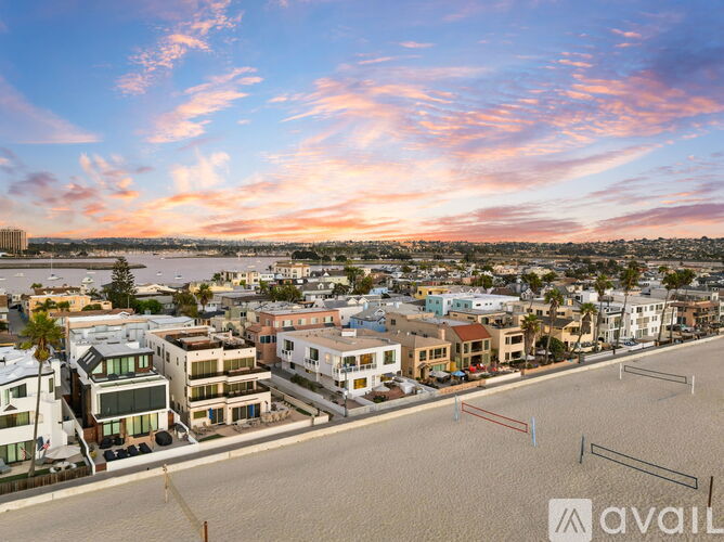 A beachfront town with buildings and a cloudy sky.