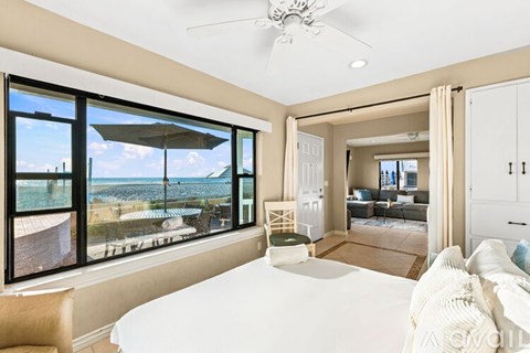 A bedroom with a large bed and a view of the beach.