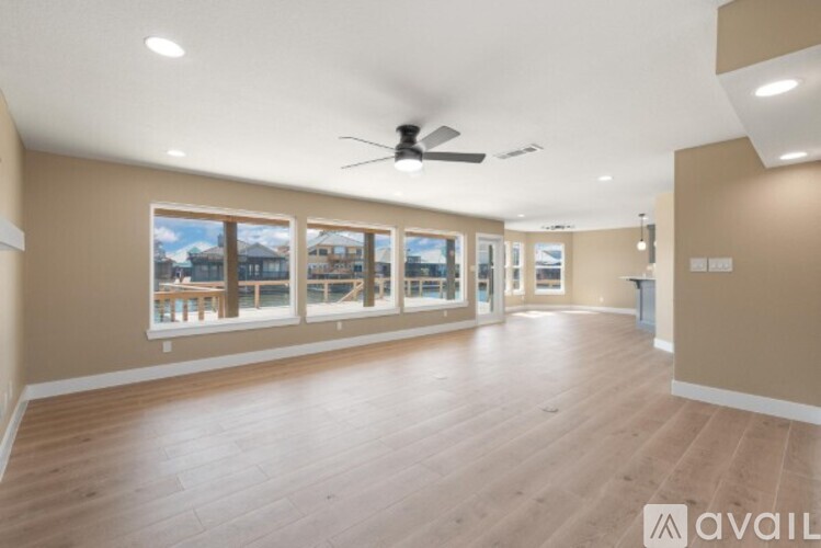 A spacious room with wooden flooring and a ceiling fan.