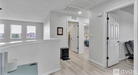 A room with white walls and a fridge on the counter.