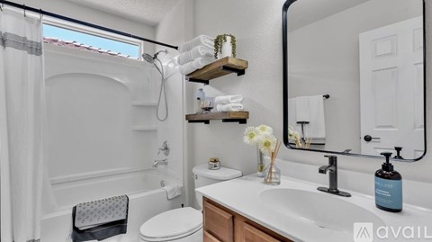 A bathroom with a white tub, sink, and toilet.