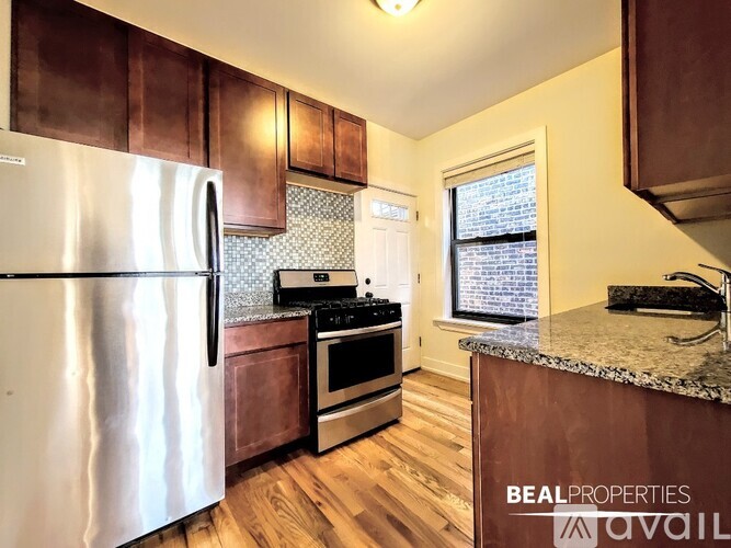 A kitchen with wooden cabinets and a stainless steel refrigerator.