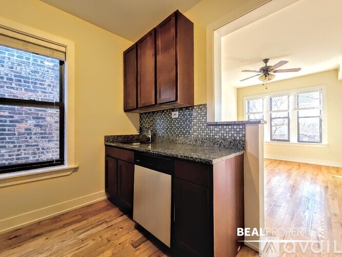 A kitchen with wooden cabinets and a black dishwasher.
